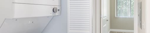 a laundry room with a washer and dryer and a door to a bathroom