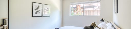 a bedroom with a bed and a lamp and a window