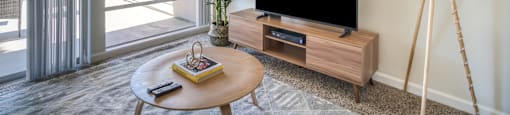 a living room with a tv and a table and a window