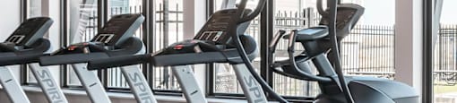 a gym with treadmills and other cardio equipment on the floor