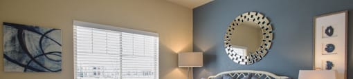 a bedroom with a bed and a mirror on the wall