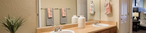 a bathroom with two sinks and a toilet and a mirror