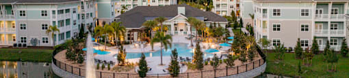 an aerial view of a swimming pool with a fountain in the middle of the water