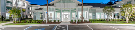 a large white house with palm trees in a parking lot