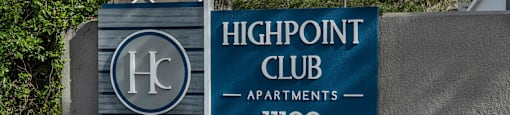 a sign for the highpoint club apartments in front of flowers
