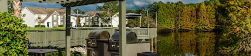 a picnic area with tables and a grill on a patio