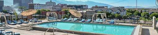a pool and spa at a hotel with a city in the background
