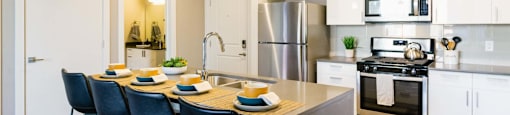 an open kitchen with a large island with blue chairs