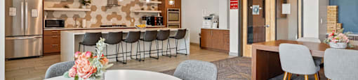 a dining room with a kitchen and a table with chairs