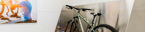 a reflection of a person on a bike in a glass display case