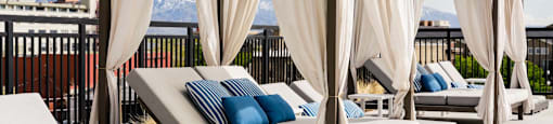 a rendering of the rooftop of a hotel with lounge chairs and umbrellas