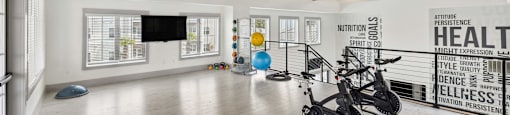 a workout room with exposed ceiling beams and a tv