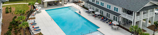 an aerial view of an apartment complex with a swimming pool at sunset