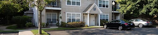 a large gray house with cars parked in front of it