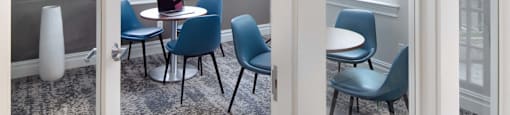 a conference room with blue chairs and a table with a laptop