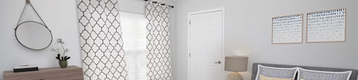a bedroom with a bed and a dresser and a window