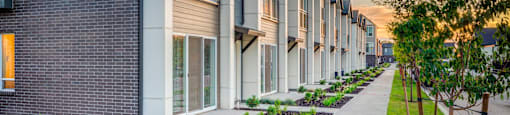 a row of townhouses with a sidewalk in front of them