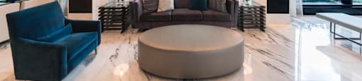 A modern living room with a large circular light fixture and a view of the city.