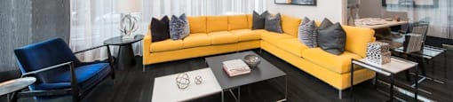 A modern living room with a yellow sofa and a blue chair.