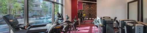 A gym with a red carpet and a variety of exercise equipment.