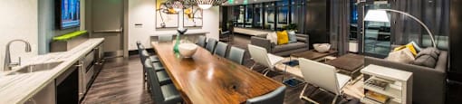 A modern kitchen with a wooden dining table and grey chairs.