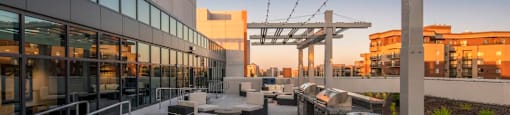 A rooftop patio with a pool and seating area.