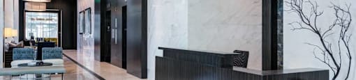 A black and white marble hallway with a vase on the right.