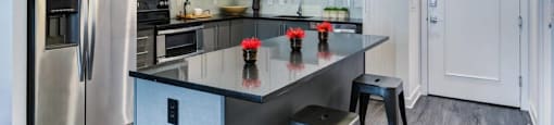 A modern kitchen with a large island and stainless steel appliances.