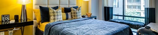 A bedroom with a bed, two lamps, and a painting on the wall.
