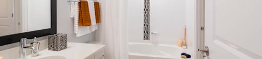A white bathroom with a toilet, sink, and bathtub.