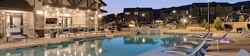 A swimming pool with loungers and a building in the background.