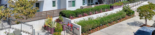 A modern apartment complex with a courtyard and parked cars.