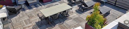 A patio with a table and chairs and a grill.