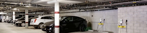 A black car is parked in a parking garage.