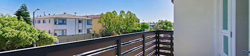 A balcony with a railing overlooks a residential area.