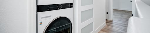 A white LG washing machine and dryer in a small laundry room.