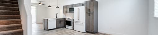 A kitchen with a refrigerator, oven, and microwave is shown.