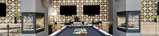 A pool table is in the middle of a room with a black and gold patterned wall.