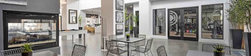 A modern dining area with a glass wall and a view of the outside.