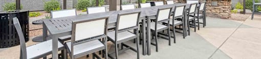 A patio with a table and chairs under a pergola.