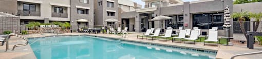 A large swimming pool in front of apartment buildings.