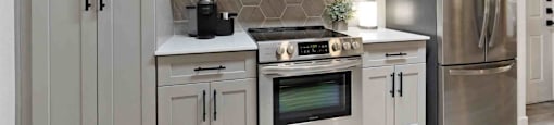 A modern kitchen with stainless steel appliances and white cabinets.