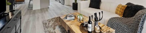 A modern living room with a white couch and a wooden coffee table.