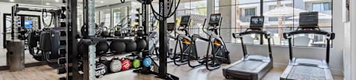 A well-equipped gym with a variety of exercise machines and weights.
