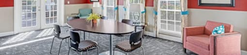 A dining room with a round table and chairs.