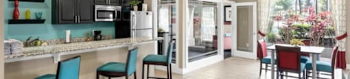 A kitchen with a bar area and a dining table.