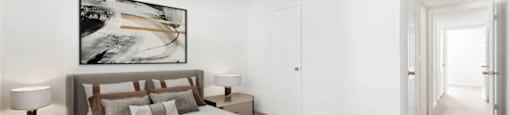 A bedroom with a large bed and a painting on the wall.