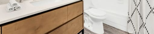 A bathroom with a white sink and a round mirror.