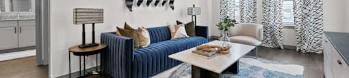 A living room with a blue sofa and a wooden table.