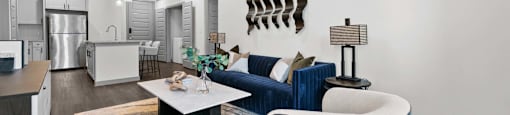 A modern living room with a blue couch and a white coffee table.